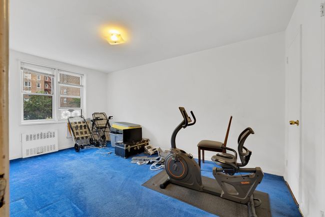 Exercise room with radiator heating unit and carpet floors | Image 8