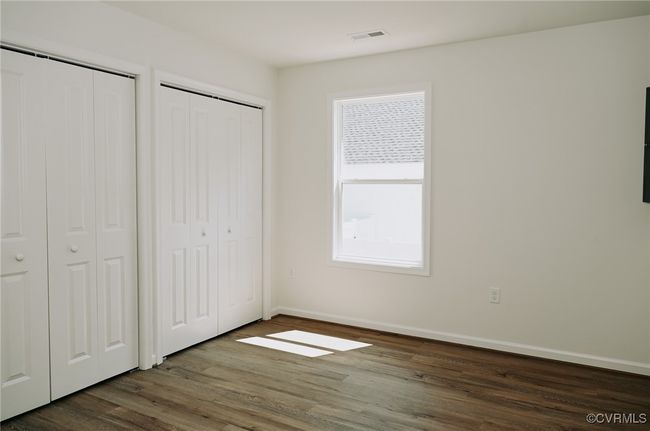 Unfurnished bedroom featuring dark hardwood / wood-style floors and two closets | Image 9