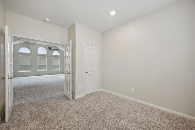 Empty room featuring carpet flooring, french doors, baseboards, and ceiling fan | Image 14