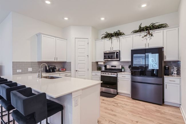Kitchen with backsplash, a peninsula, and stainless steel appliances | Image 10