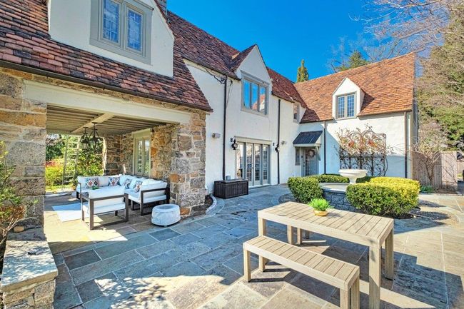 Rear view of property featuring bluestone patio, French door access, an outdoor relaxation area, and stucco siding. | Image 30