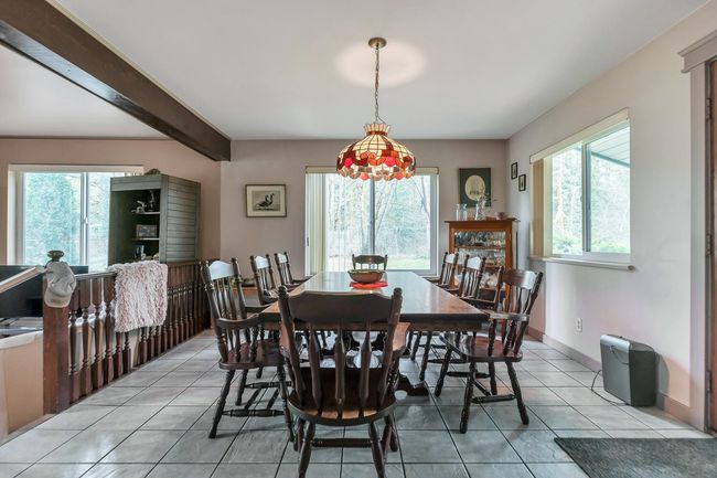 Dining space featuring light tile patterned floors, beam ceiling, and a healthy amount of sunlight | Image 11