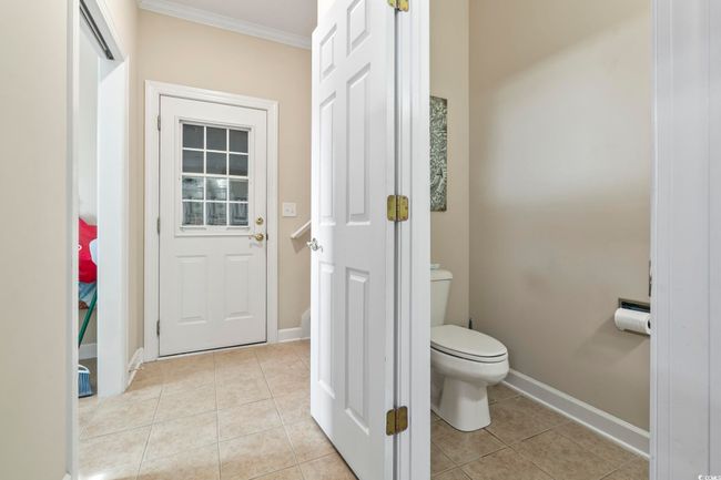 Bathroom with ornamental molding, toilet, tile patterned floors, and baseboards | Image 11