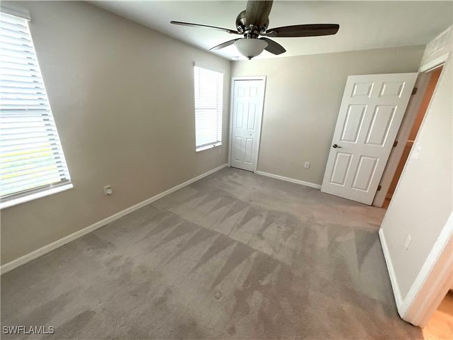 Unfurnished bedroom with carpet, a closet, and a ceiling fan | Image 9