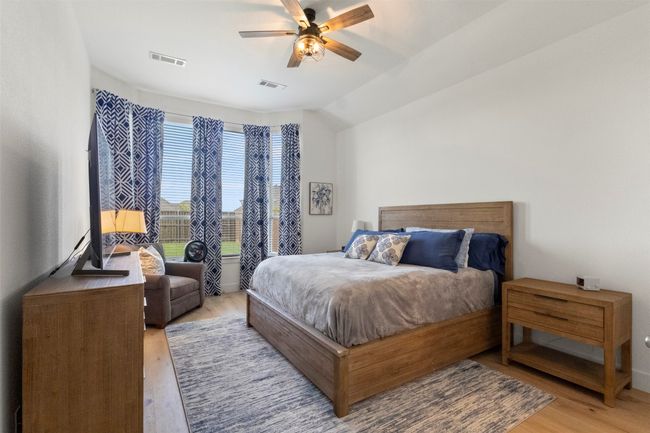Bedroom with light wood-type flooring, ceiling fan, and vaulted ceiling | Image 5