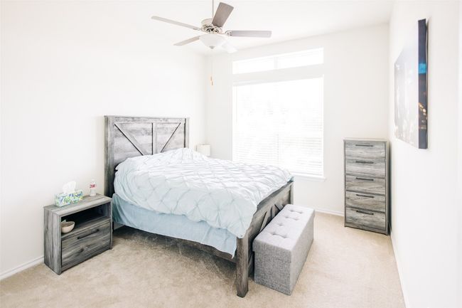 Bedroom with light carpet, baseboards, and ceiling fan | Image 8