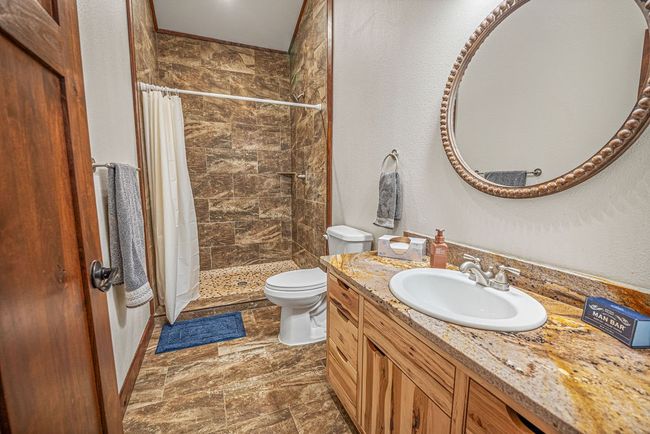 Bathroom featuring toilet, a stall shower, and vanity | Image 21