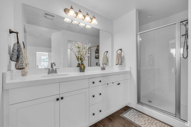 Full bathroom featuring double vanity, a stall shower, and a sink | Image 15