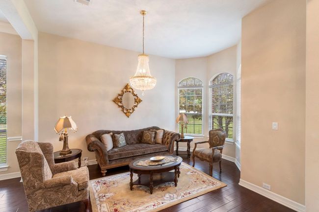 Living area featuring dark wood-style floors, baseboards, and a chandelier | Image 8