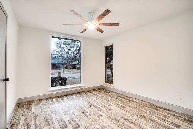 Spare room featuring wood finished floors, a ceiling fan, and baseboards | Image 13