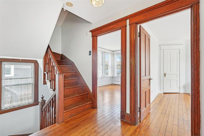 Stairs featuring hardwood / wood-style floors, a baseboard heating unit, and baseboards | Image 26