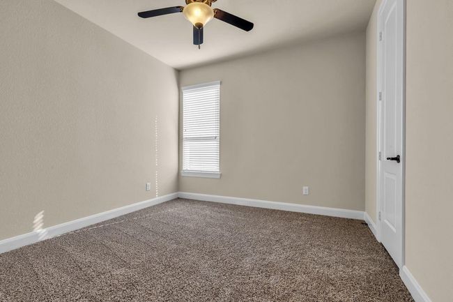 The fourth downstairs bedroom offers privacy and flexibility, ideal for guests or multigenerational living with easy access to a nearby full bath, this room provides comfort and convenience on the main level. | Image 27