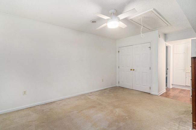 Bedroom with attic access, light colored carpet, and a closet | Image 18