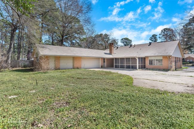 Ranch-style home featuring brick siding, fence, a front yard, a sunroom, and driveway | Image 21
