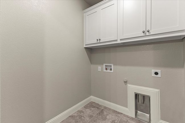 Laundry area featuring cabinet space, washer hookup, hookup for an electric dryer, gas dryer hookup, and light tile patterned flooring | Image 29