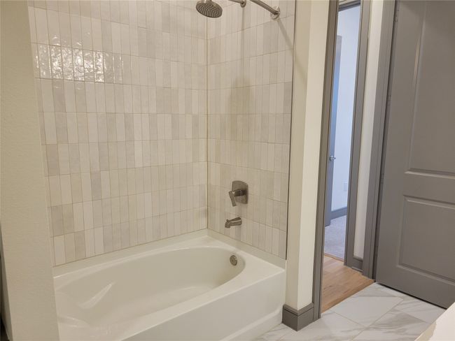 Full bath featuring marble finish floor, baseboards, and shower / washtub combination | Image 17
