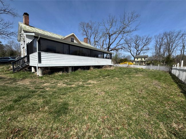 Back of property featuring a chimney, fence, a yard, metal roof, and a sunroom | Image 32