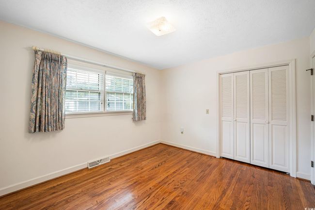 Unfurnished bedroom featuring wood finished floors, baseboards, and a closet | Image 18