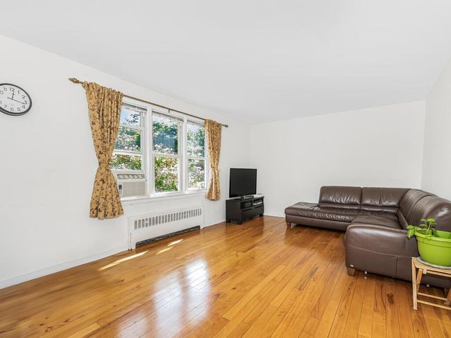 Living room with hardwood / wood-style floors and radiator heating unit | Image 4