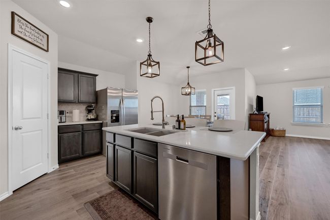 Kitchen with stainless steel appliances, light wood finished floors, light countertops, backsplash, and recessed lighting | Image 14
