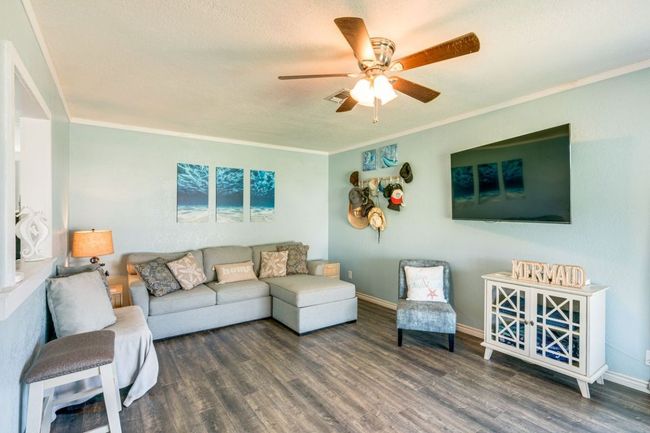 Living area with visible vents, crown molding, wood finished floors, and a ceiling fan | Image 5
