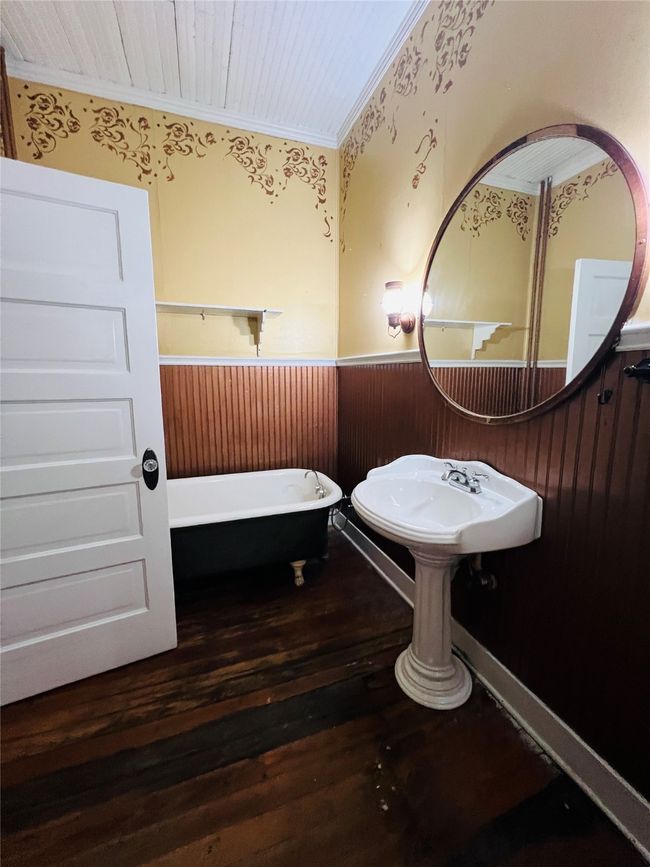 Bathroom featuring a wainscoted wall, a freestanding bath, ornamental molding, hardwood / wood-style flooring, and wood walls | Image 11