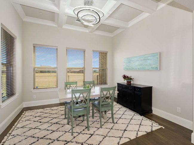 The dining area offers stunning backyard views and is enhanced by a coffered ceiling | Image 7