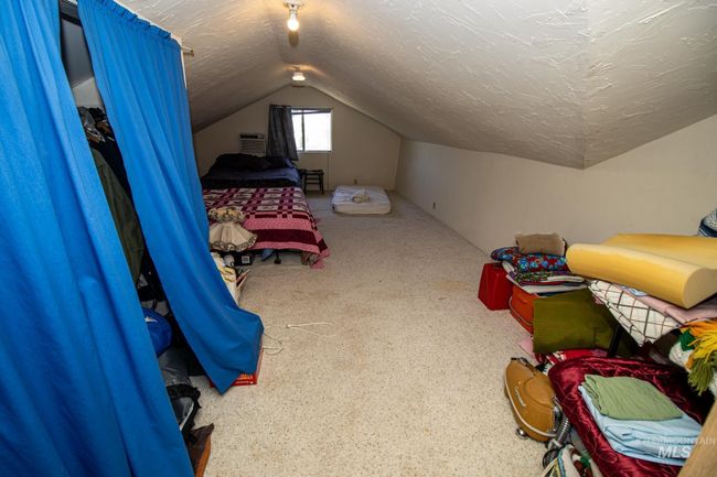 Bedroom featuring vaulted ceiling, a textured ceiling, a wall mounted AC, and carpet floors | Image 30