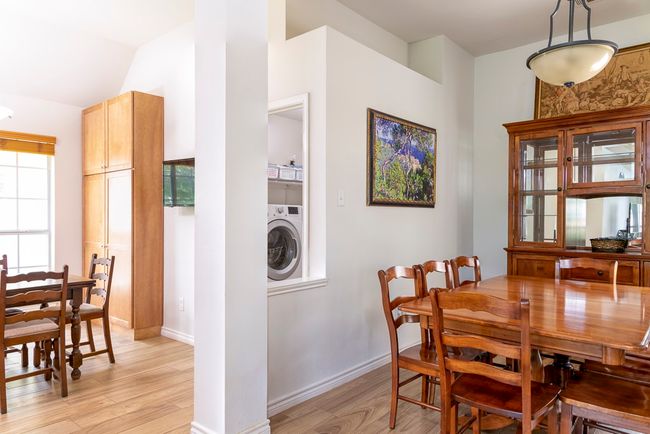 Dining space with washer / dryer, light wood finished floors, and vaulted ceiling | Image 6