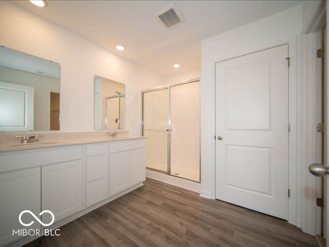 full bathroom with visible vents, a shower stall, wood finished floors, and a sink | Image 29