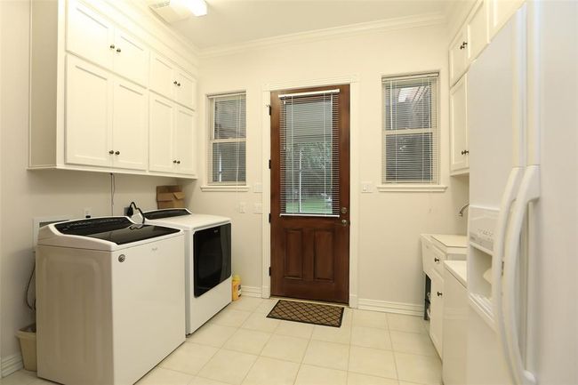 Utility room has plenty of space for extra refrigerator and chest deep freeze in addition to a washer and dryer. Plenty of storage space. | Image 29