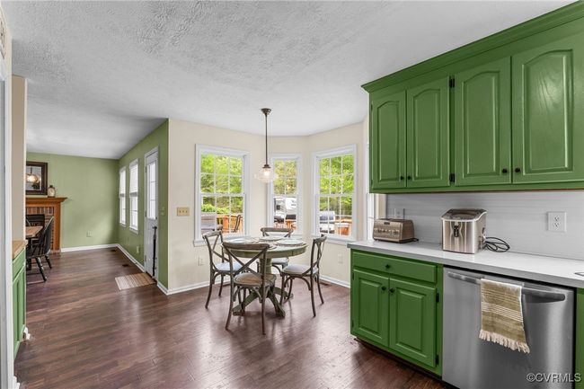 Kitchen featuring dishwasher, light countertops, a fireplace, and a healthy amount of sunlight | Image 15