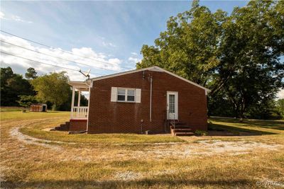 View of property exterior featuring a lawn and a storage unit | Image 2