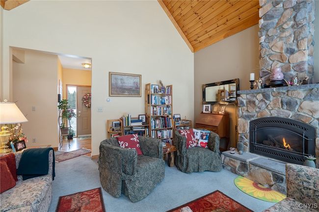 Living room with rock accented propane fireplace | Image 9