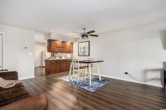 Dining space with dark wood finished floors, a textured ceiling, and a ceiling fan | Image 15