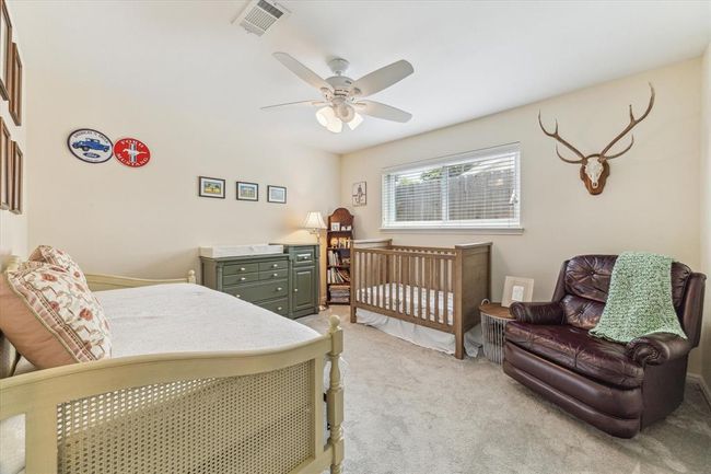 Cozy secondary bedroom featuring neutral tones and a ceiling fan for added comfort. | Image 16