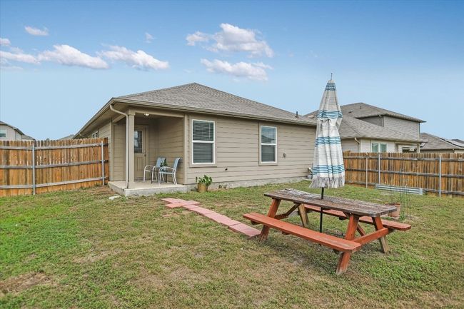 Back of house featuring a fenced backyard, a yard, and a patio area | Image 19