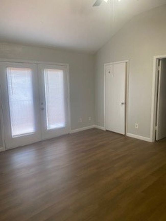 Spare room featuring vaulted ceiling, ceiling fan, dark wood finished floors, baseboards, and plenty of natural light | Image 16