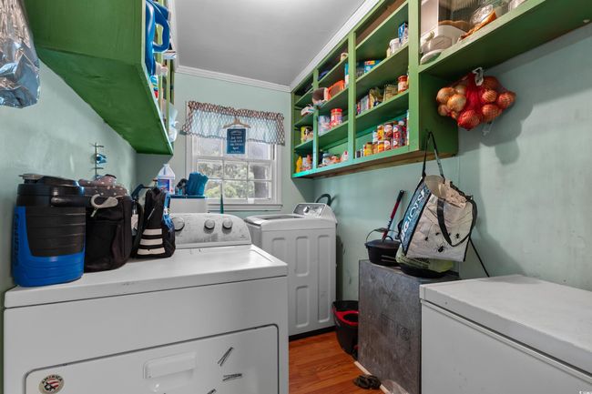 Laundry room with washing machine and clothes dryer, wood finished floors, and ornamental molding | Image 20