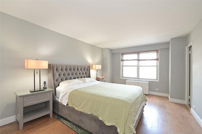 Bedroom with radiator, baseboards, and light wood-style floors | Image 8