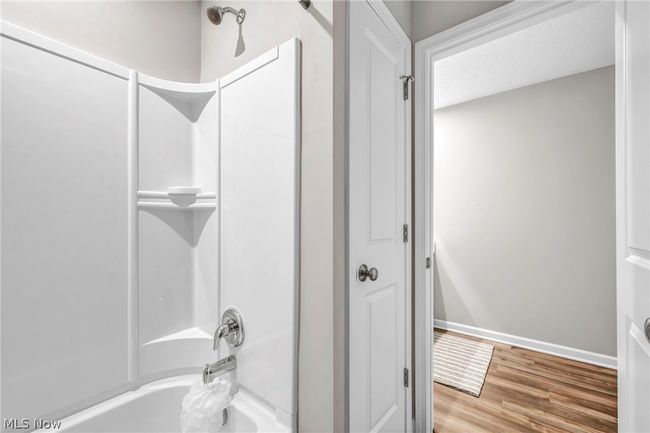 Bathroom with hardwood / wood-style flooring and tub / shower combination | Image 37
