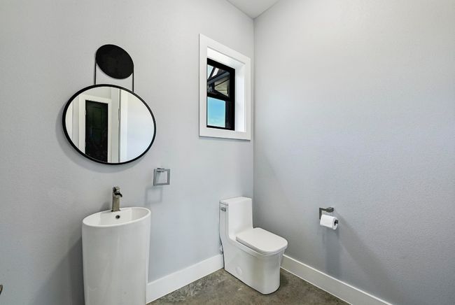 The main floor also provides a convenient guest powder room with a modern pedestal sink. | Image 35