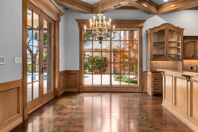Unfurnished dining area featuring a chandelier, french doors, a wainscoted wall, plenty of natural light, and a decorative wall | Image 23