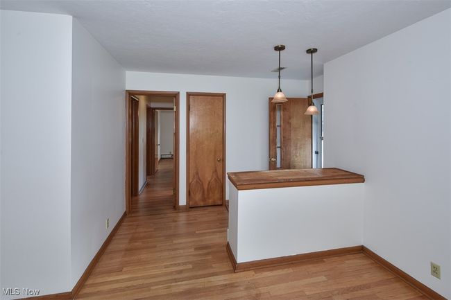 Kitchen with light wood-style flooring, baseboards, and hanging light fixtures | Image 19