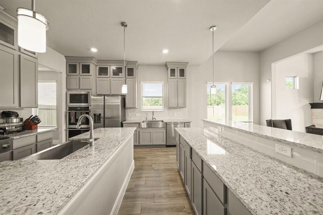 Pendant lighting and stainless steel appliances create a clean and contemporary space. | Image 9