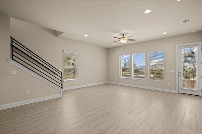 Unfurnished living room featuring light wood finished floors, stairway, and a healthy amount of sunlight | Image 4