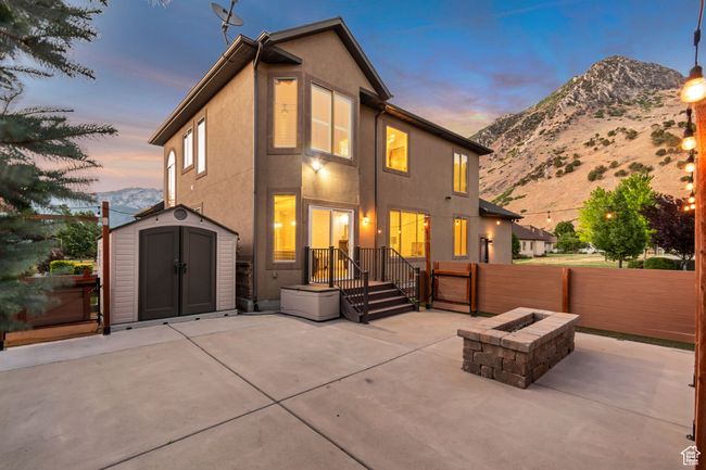 Rear view of property featuring a patio, a shed, an outdoor fire pit, and stucco siding | Image 42