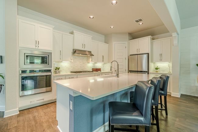 Kitchen featuring appliances with stainless steel finishes, a sink, light wood-style floors, tasteful backsplash, and recessed lighting | Image 14