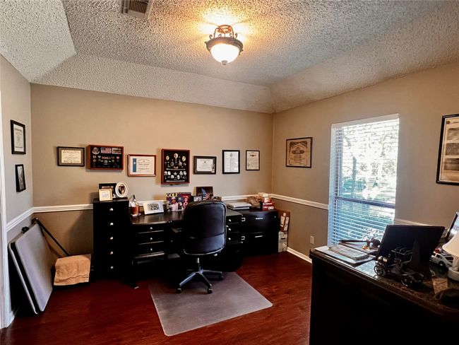 Office area with a tray ceiling, dark wood-type flooring, and a textured ceiling | Image 5