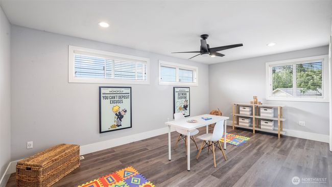 This flexible upstairs room serves perfectly as a guest bedroom, playroom, or studio, featuring hardwood floors, multiple windows, and two spacious closets | Image 28